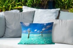 Sierkussen Hangmat Op Het Strand Voor Buiten - Een Hangmat Die Omringd Is Door Het Lichtblauwe Water - 50x30 Cm - Rechthoekig Weerbestendig Tuinkussen / Tuinmeubelkussen Van Polyester -Pillowmonkey 1200x800 3020