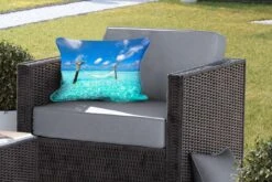 Sierkussen Hangmat Op Het Strand Voor Buiten - Een Hangmat Die Omringd Is Door Het Lichtblauwe Water - 50x30 Cm - Rechthoekig Weerbestendig Tuinkussen / Tuinmeubelkussen Van Polyester -Pillowmonkey 1200x800 3021